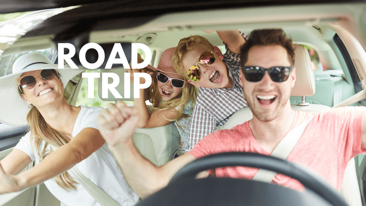 A family in a car posing happily with the words Road Trip